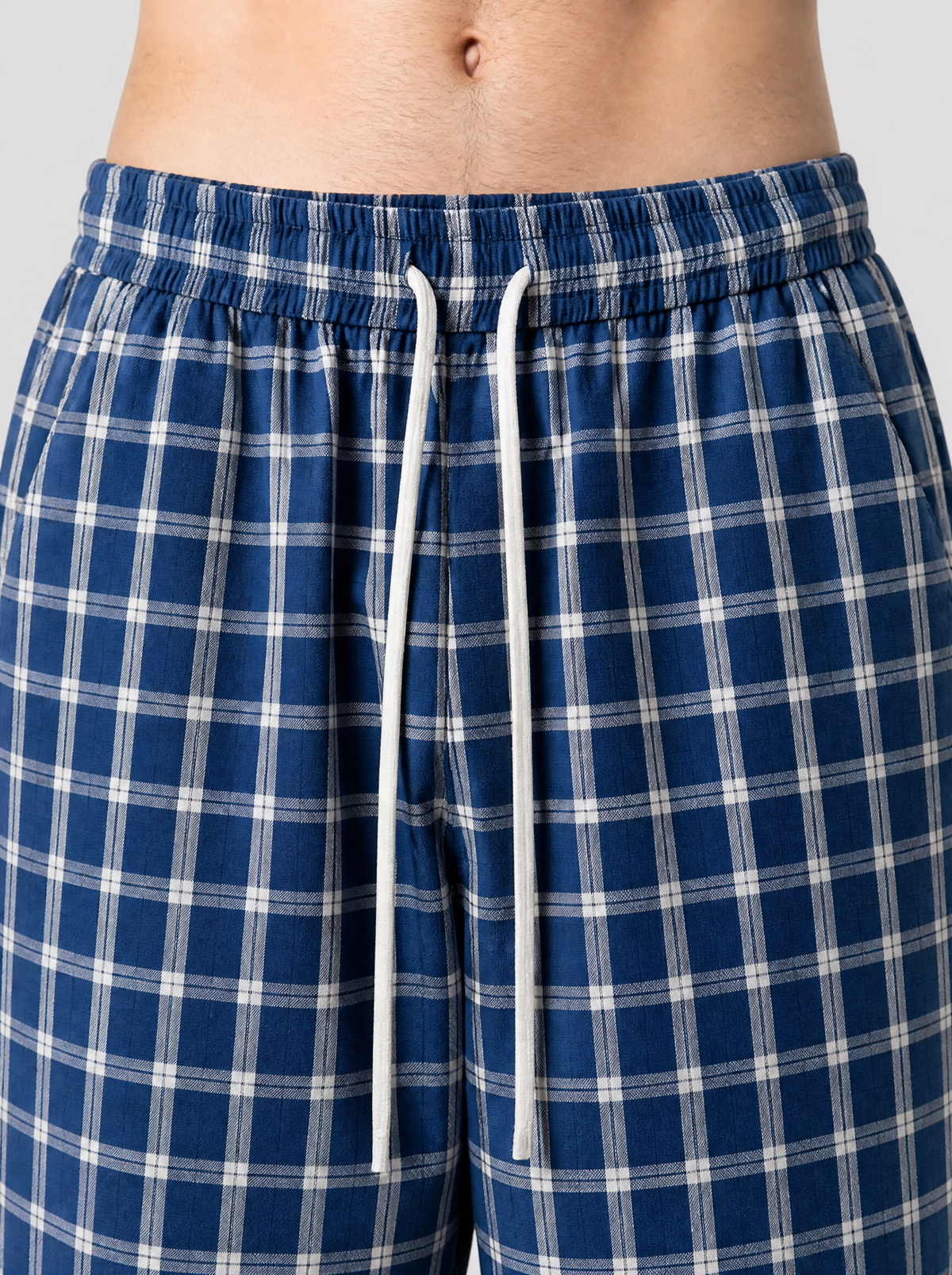 Photo détail | Gros plan sur le tissu à carreaux bleu et blanc et le cordon de serrage blanc du pantalon large | Variante : Bleu