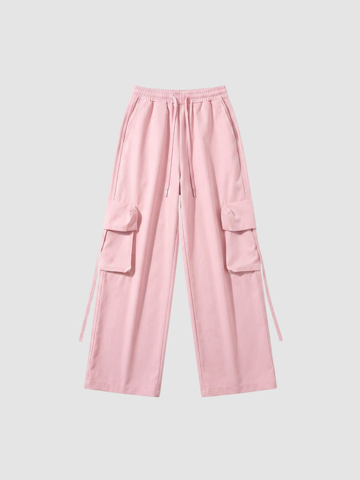 Pantalon cargo parachute rose poudré jambe large avec taille élastique, cordon et poches à rabat sur les côtés.