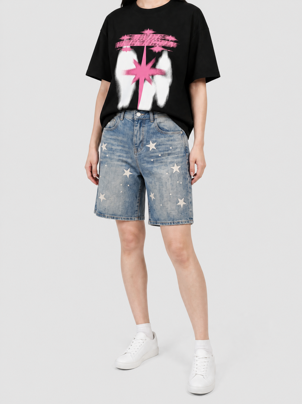 Autre vue | Bermuda en jean bleu délavé imprimé étoiles crème, porté de trois quarts par une femme avec un t-shirt noir à étincelle rose