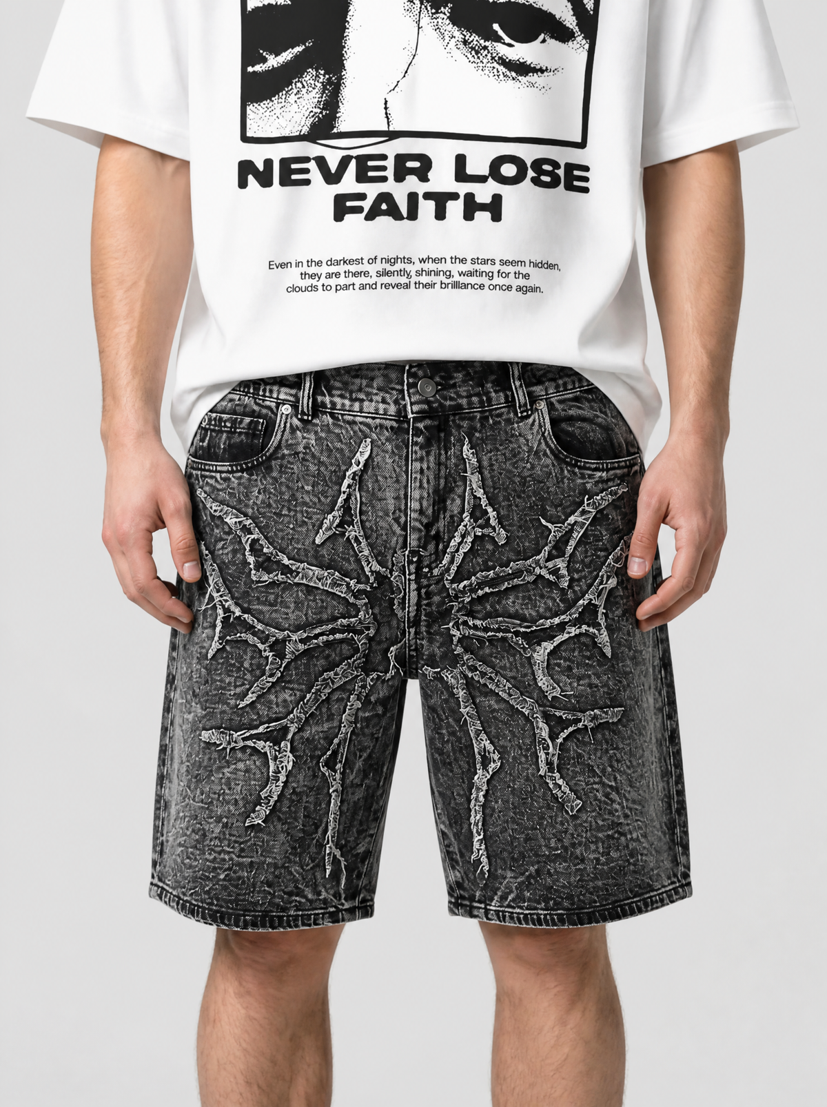 Photo détail | Gros plan sur les branches épineuses effilochées gris clair cousues sur le denim noir délavé neige du short