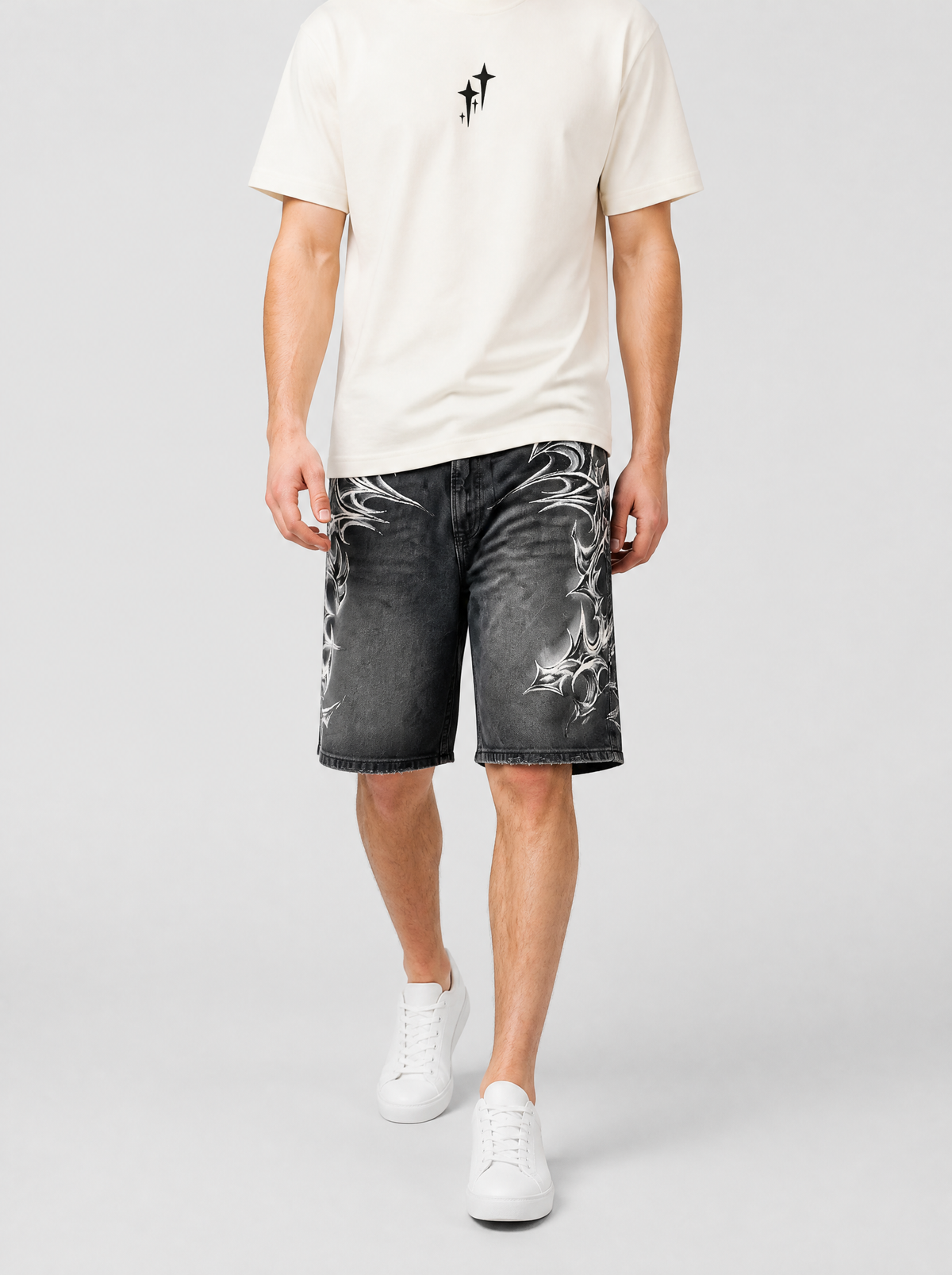 Autre vue | Homme marchant de face en jort noir délavé à motifs tribaux épineux blancs, porté avec un t-shirt crème minimaliste