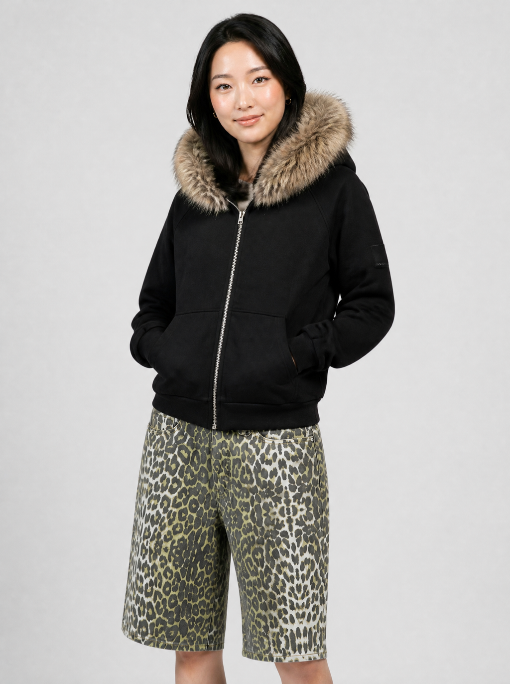 Autre vue | Femme de trois quarts en sweat zippé noir à capuche bordée de fausse fourrure beige, avec un short en jean léopard | Variante : Noir