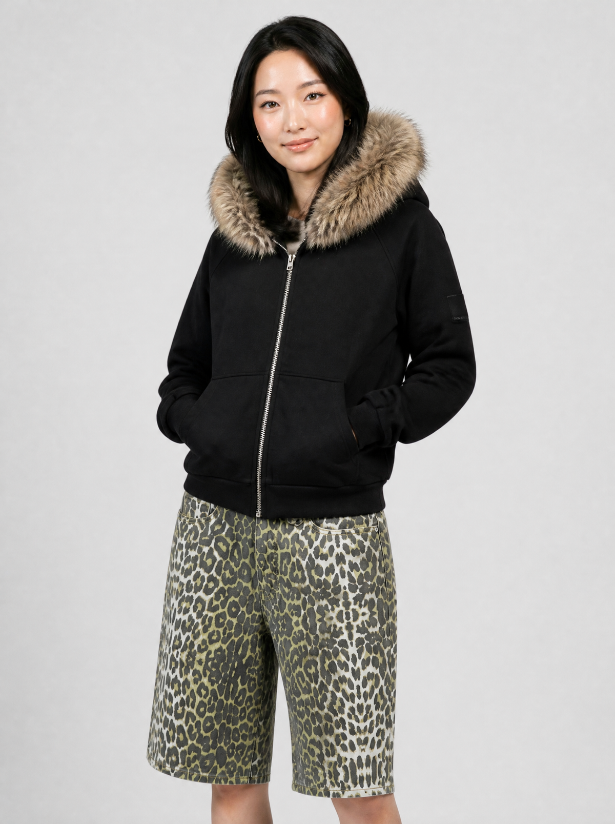 Autre vue | Femme de trois quarts en sweat zippé noir à capuche bordée de fausse fourrure beige, avec un short en jean léopard | Variante : Noir