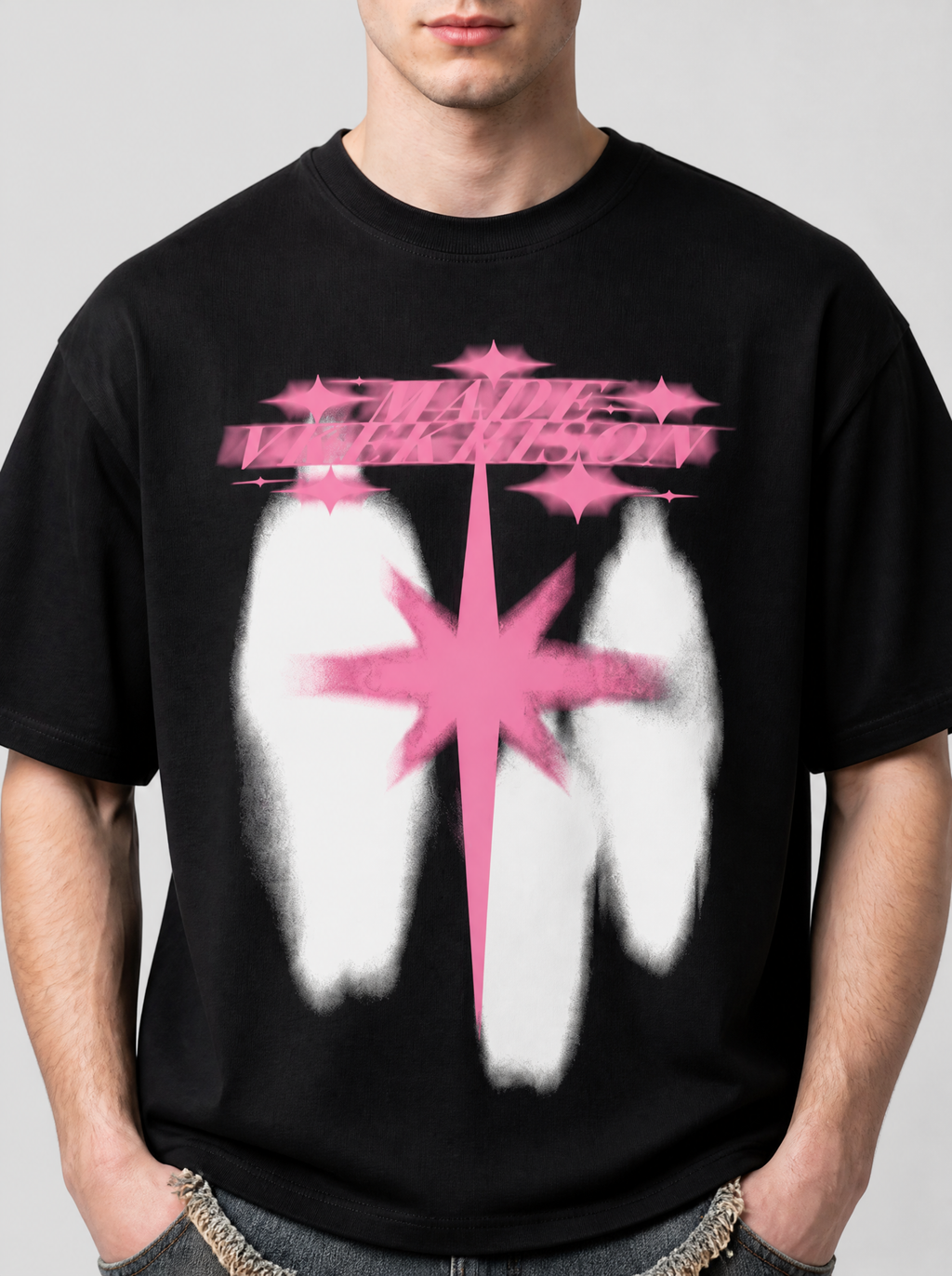 Photo détail | Gros plan sur la poitrine du t-shirt noir : lettrage rose flou, étincelles roses et grande étoile rose sur formes blanches | Variante : Noir