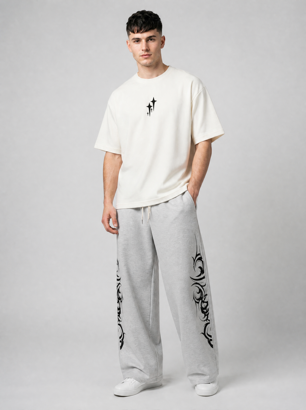 Autre vue | Homme portant de face le t-shirt crème minimaliste à petites étoiles noires, avec un jogging gris à motifs tribaux | Variante : Blanc