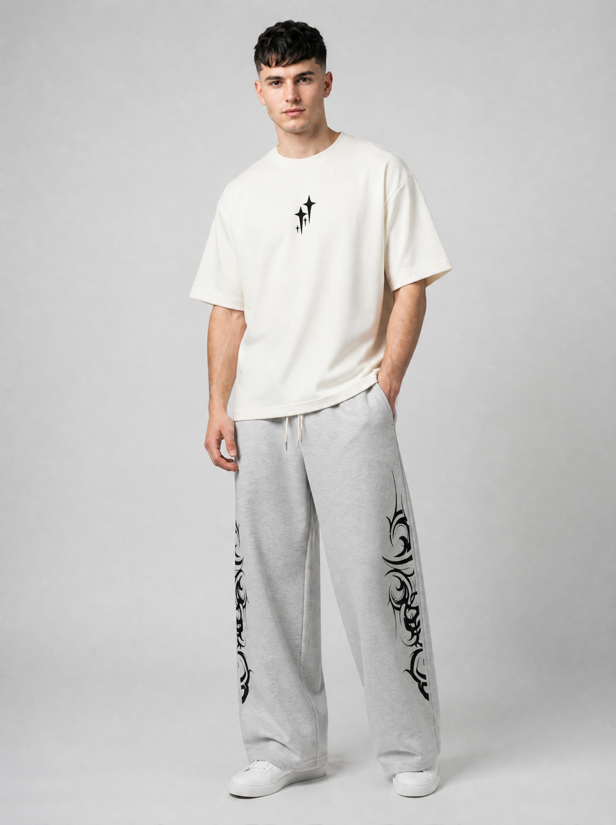 Autre vue | Homme portant de face le t-shirt crème minimaliste à petites étoiles noires, avec un jogging gris à motifs tribaux | Variante : Blanc