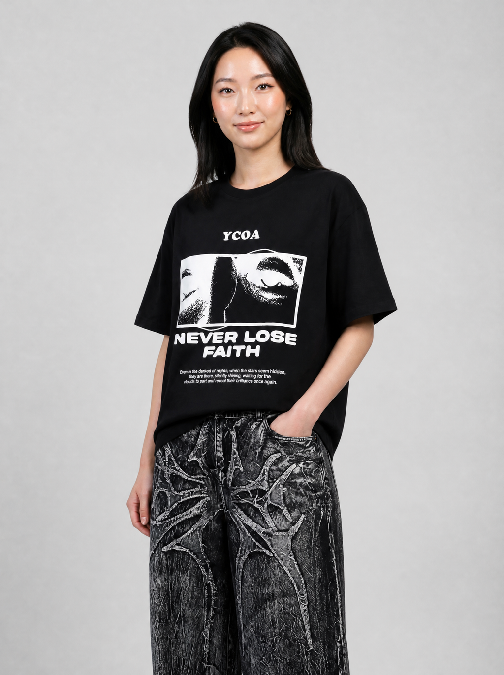 Autre vue | Femme de trois quarts en t-shirt noir oversize Never Lose Faith avec photo de regard encadrée, et jean noir gothique | Variante : Noir
