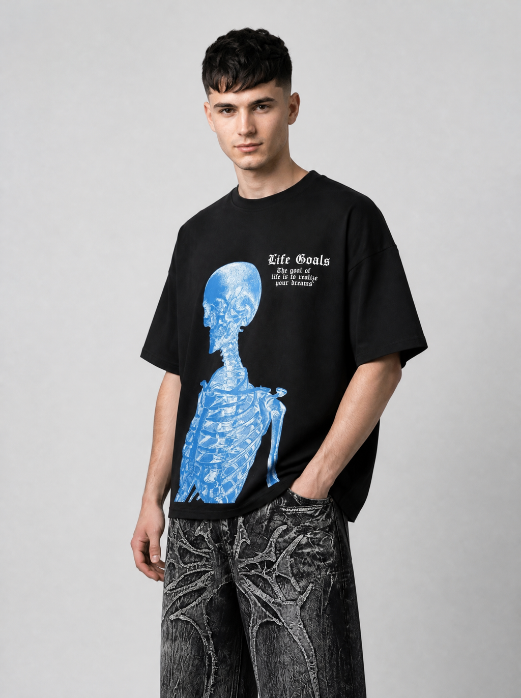 Autre vue | Homme de trois quarts en t-shirt noir oversize avec squelette bleu façon radiographie et texte Life Goals, et jean gothique | Variante : Noir