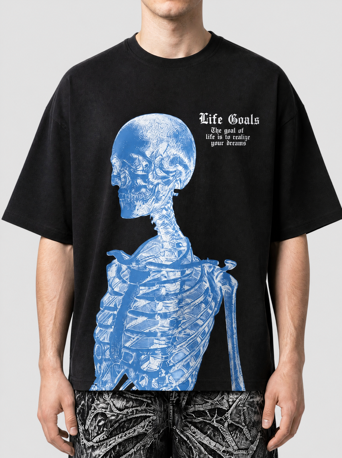 Photo détail | Gros plan sur la poitrine du t-shirt noir : crâne bleu de profil façon radiographie et inscription gothique Life Goals | Variante : Noir