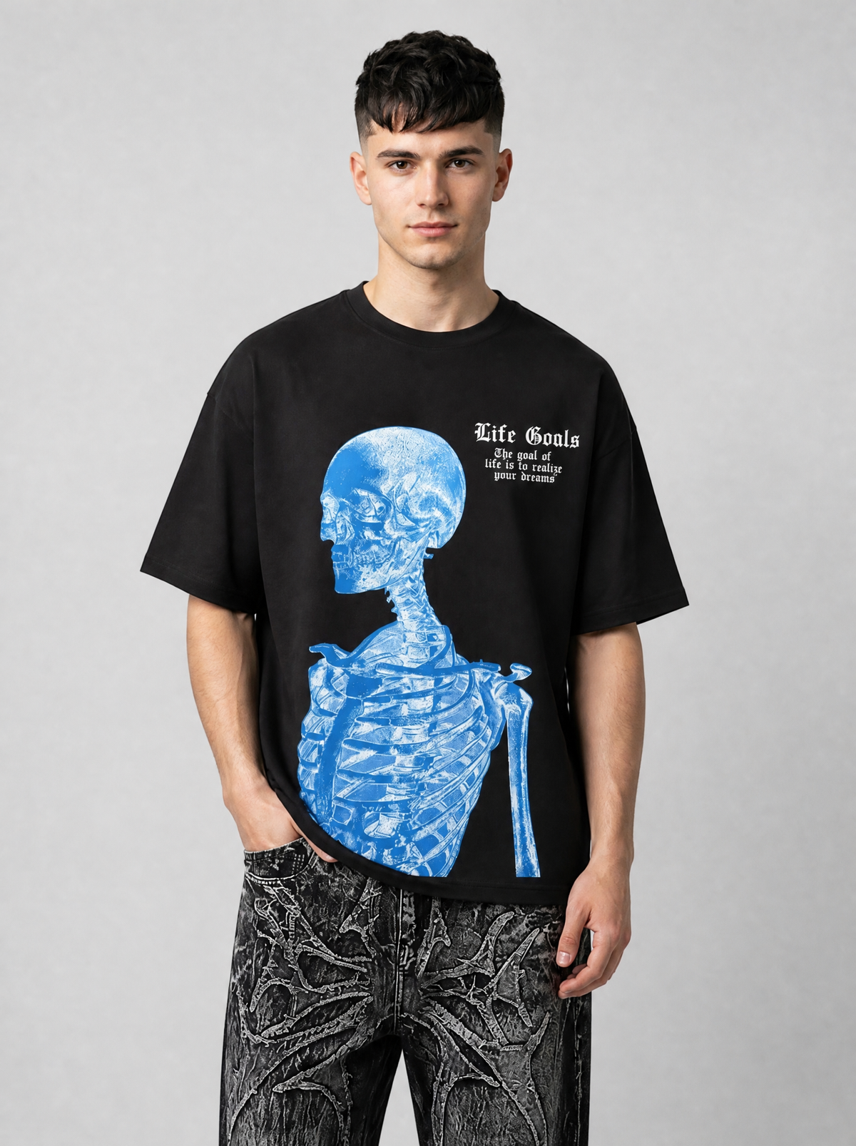 Autre vue | Homme de face en t-shirt noir imprimé squelette bleu de profil et lettrage gothique blanc, avec un jean noir délavé | Variante : Noir