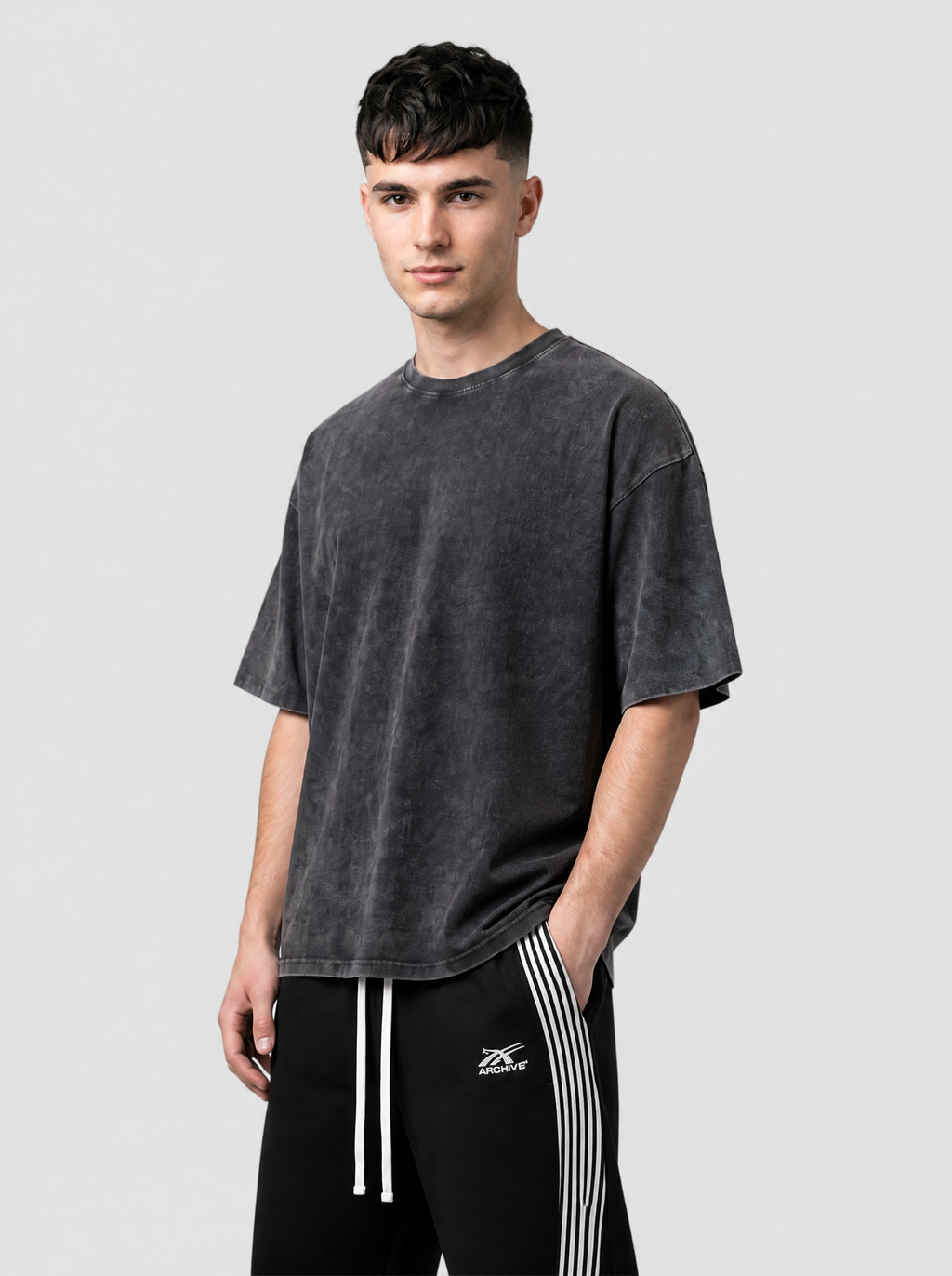 Autre vue | Homme portant le t-shirt oversize uni noir délavé à l’acide, vu de trois quarts avec un jogging noir à bandes | Variante : Noir