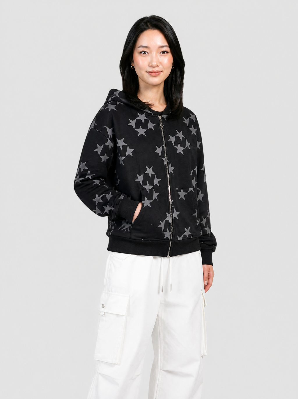 Autre vue | Femme de trois quarts en sweat zippé noir à motif d'étoiles grises sur tout le vêtement, avec un cargo parachute blanc | Variante : Noir
