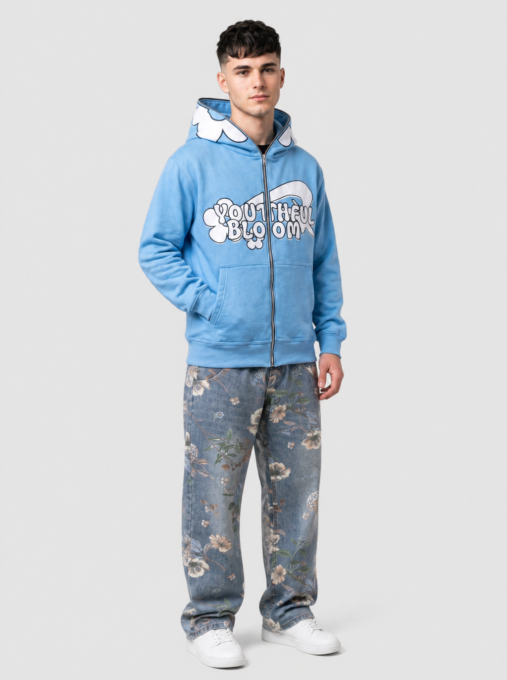 Autre vue | Homme de trois quarts en sweat zippé bleu ciel lettrage Youthful Bloom et fleurs blanches, avec un jean bleu à fleurs
