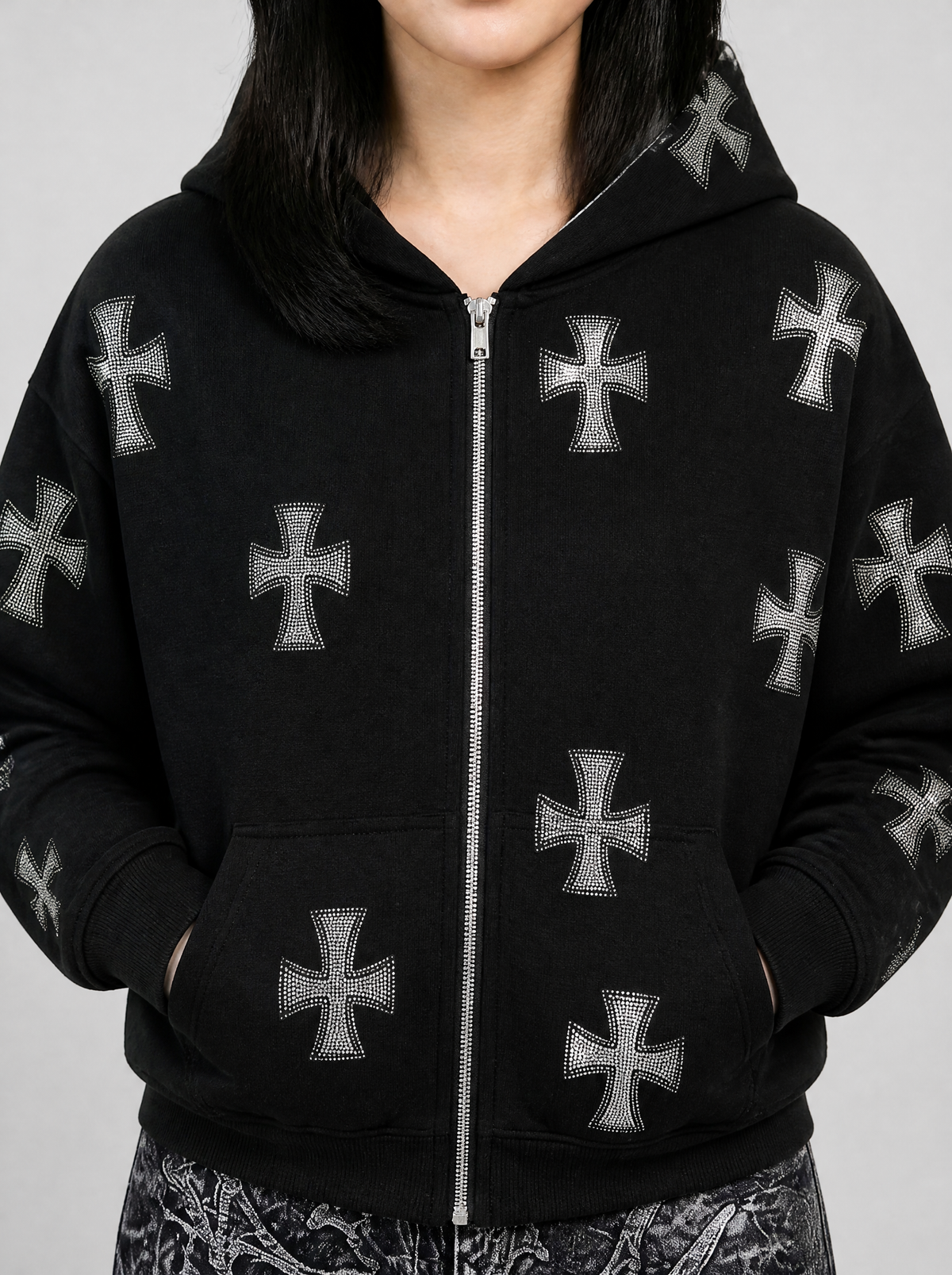 Photo détail | Gros plan sur la poitrine du sweat zippé noir : croix gothiques pattées en strass gris de part et d'autre du zip argenté | Variante : Noir