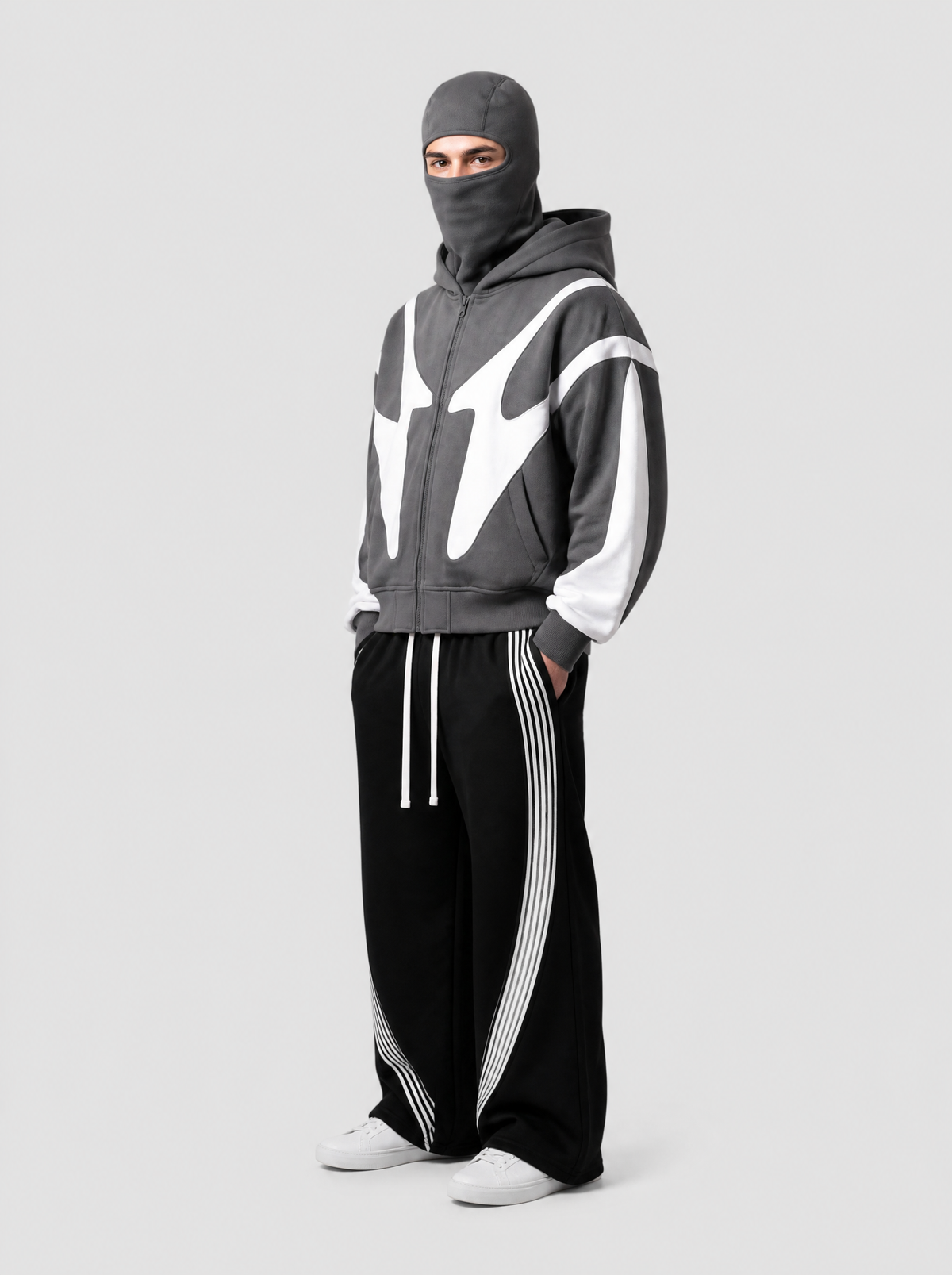 Autre vue | Homme de trois quarts en sweat zippé gris anthracite à cagoule intégrée et empiècements blancs, avec un jogging noir rayé | Variante : Gris