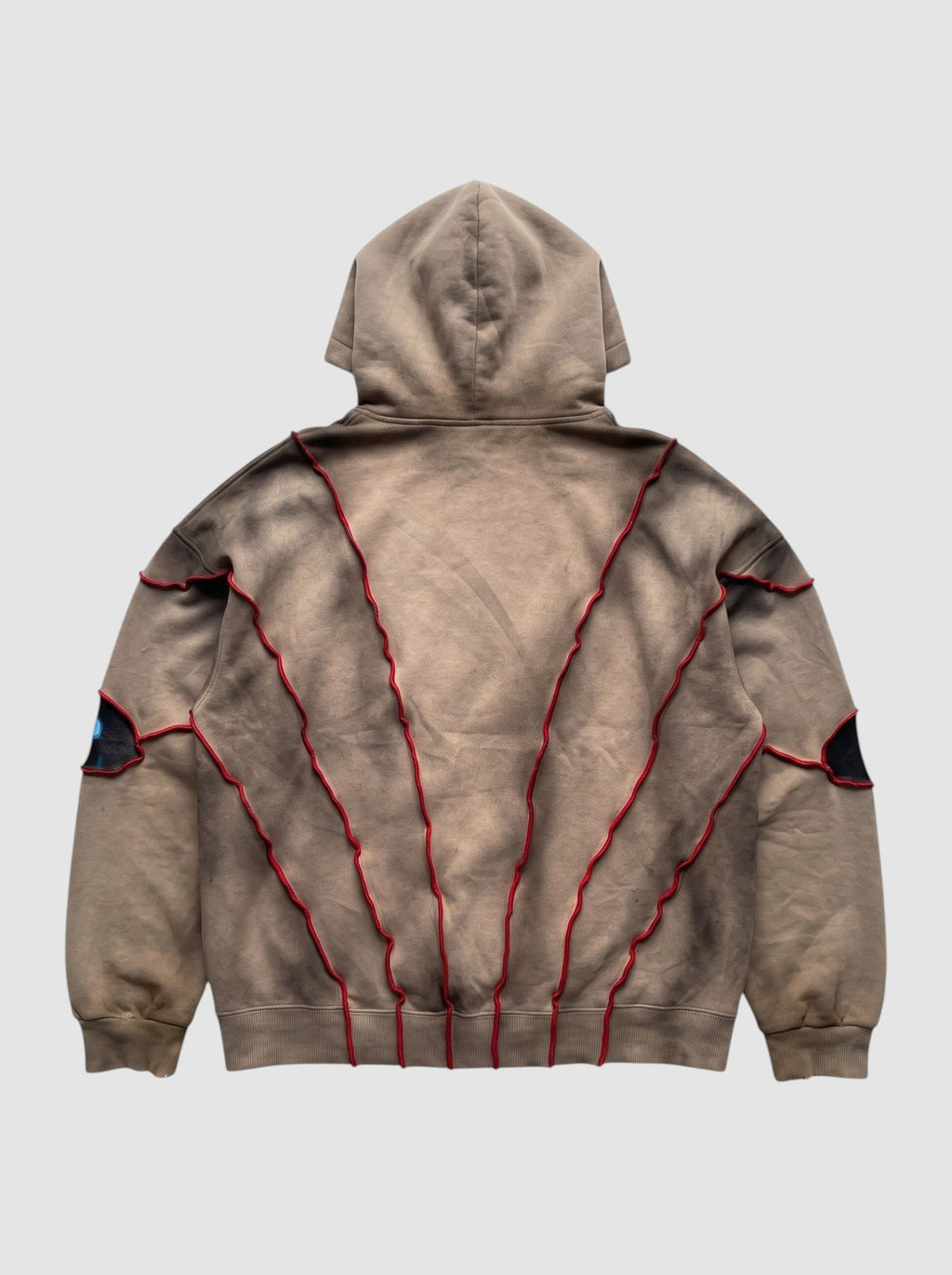 Back view of Y2K Avenue oversized beige faded hoodie with red raised seams and patchwork eye details
