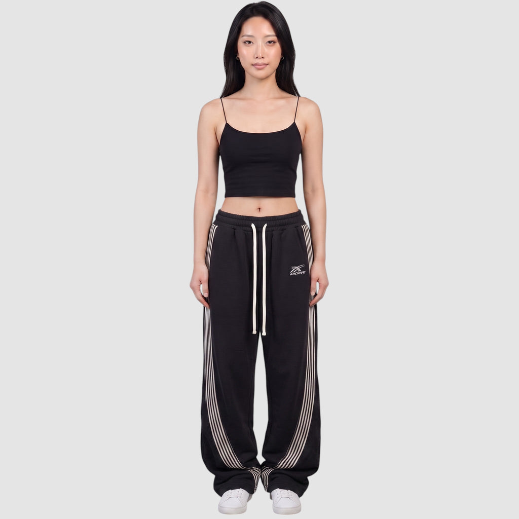 Y2K Avenue black baggy fleece joggers with white side stripes and drawstring waist worn by a model
