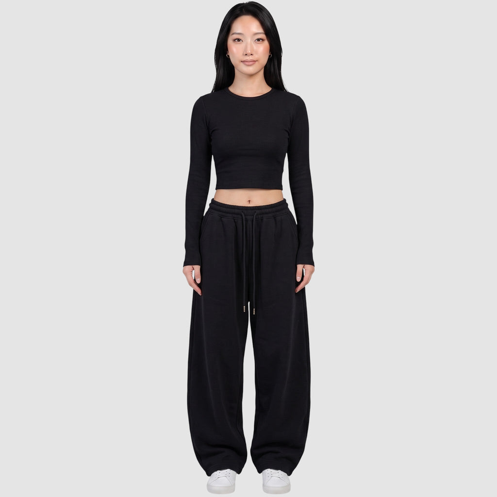 Y2K AVENUE black barrel leg sweatpants with a high elastic waist and drawstring, worn by a model with a crop top.