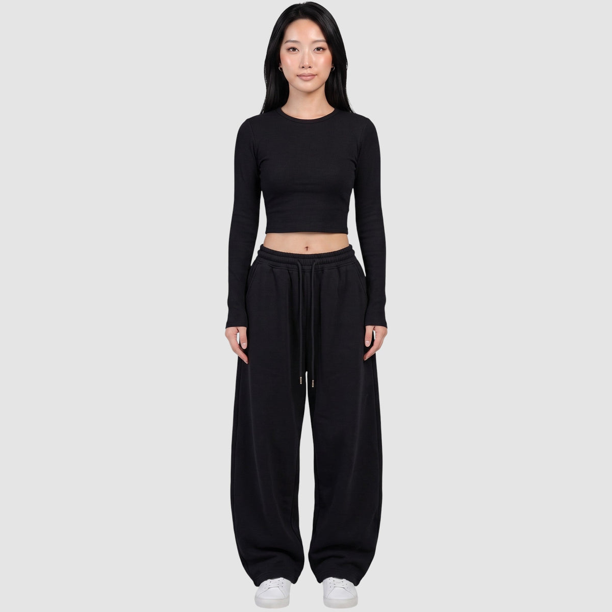 Y2K AVENUE black barrel leg sweatpants with a high elastic waist and drawstring, worn by a model with a crop top.