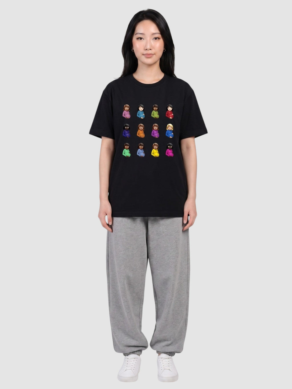 Y2K Avenue black polyester t-shirt with a grid of colorful emoji prints worn by a woman with grey sweatpants