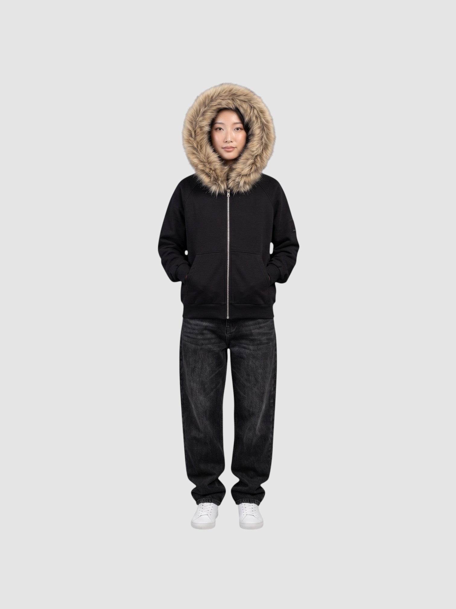Model wearing a Y2K Avenue black zip-up hoodie with a large beige faux fur hood trim and ribbed cuffs.