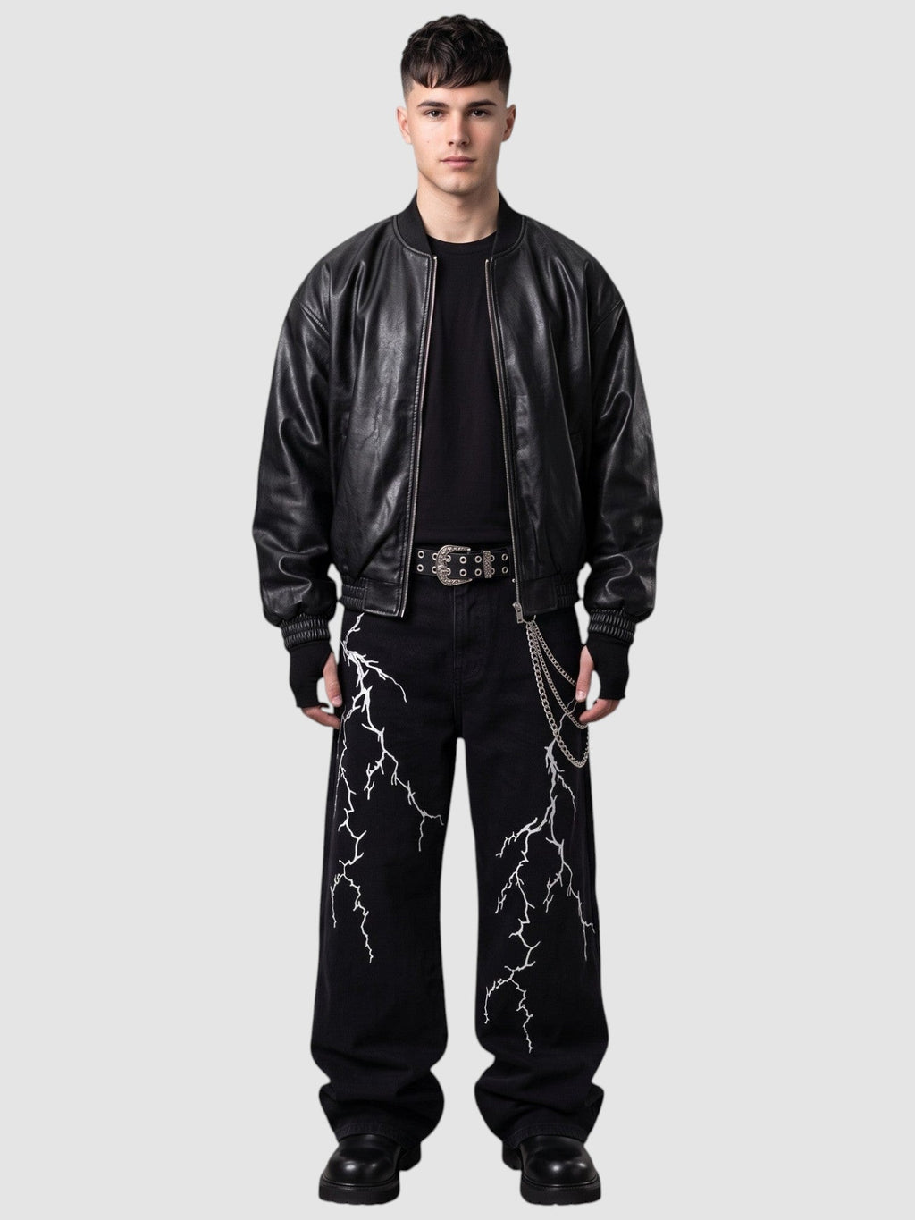 Y2K AVENUE black wide-leg denim jeans featuring white lightning embroidery, worn by a model with a leather jacket.
