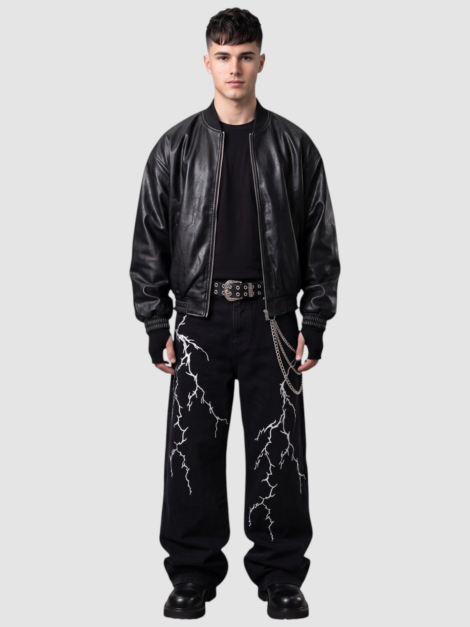 Y2K AVENUE black wide-leg denim jeans featuring white lightning embroidery, worn by a model with a leather jacket.