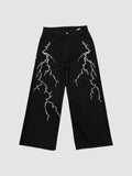 Y2K Avenue black wide-leg denim jeans featuring white embroidered lightning bolt patterns on both legs.