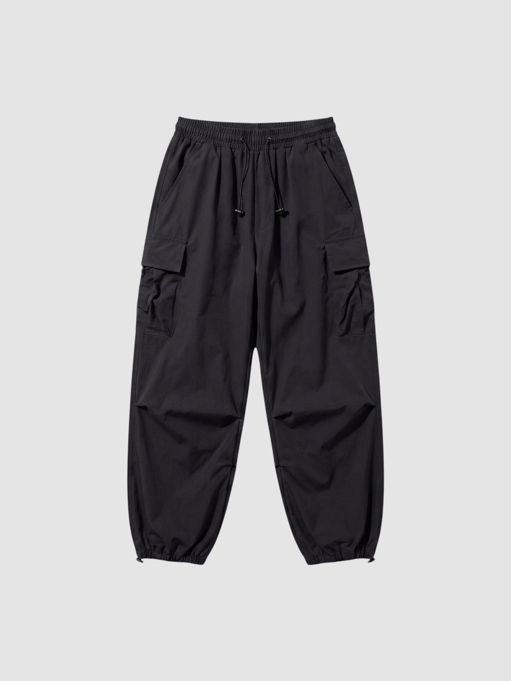 Y2K Avenue black parachute cargo pants with a loose fit, elastic drawstring waist, and side flap pockets.