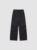 Y2K AVENUE black parachute pants with high elastic waist, adjustable drawstring cuffs, and pleated knee detailing.