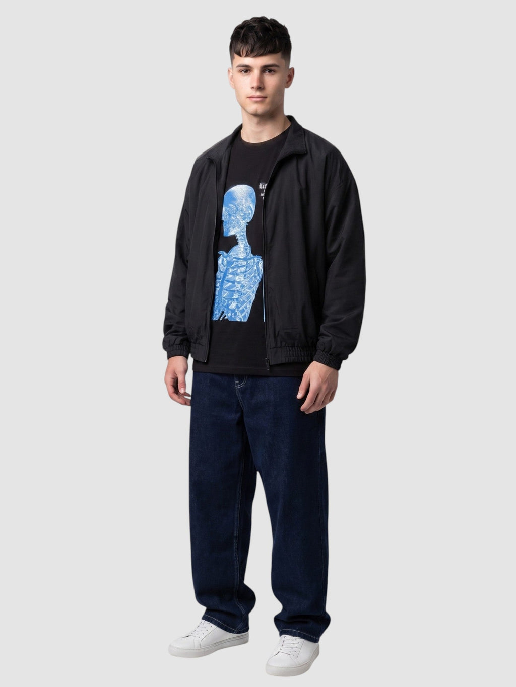 Y2K Avenue black cotton t-shirt with blue skeleton graphic print worn by a man with a black jacket and baggy jeans