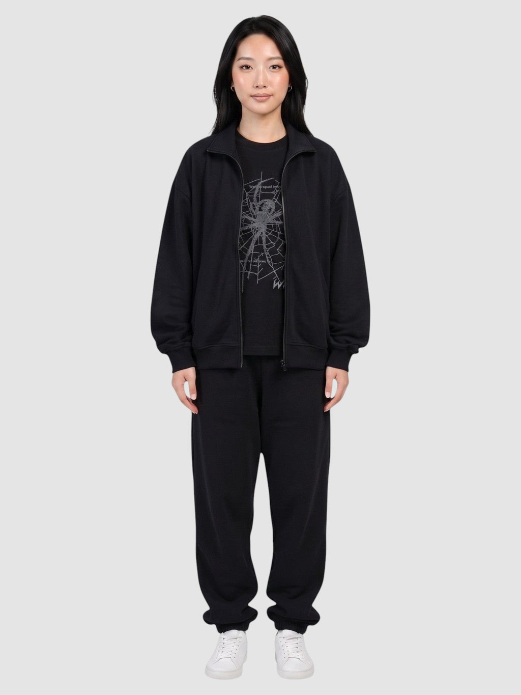 Y2K Avenue black oversized t-shirt with dark grey spider web print worn by a model in a matching tracksuit