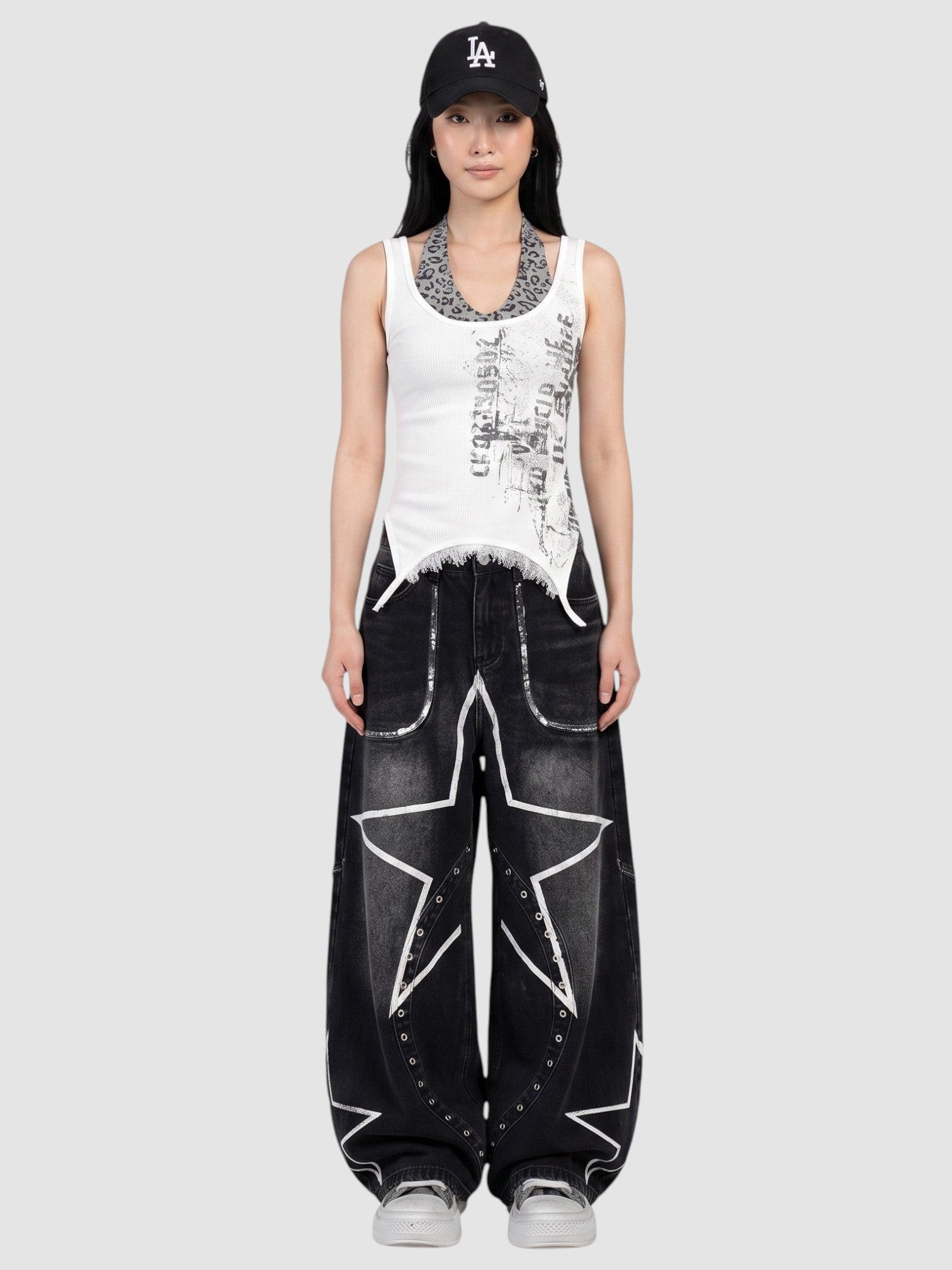 Y2K AVENUE baggy black wide leg jeans with white star prints and metal eyelets worn low-rise by a model