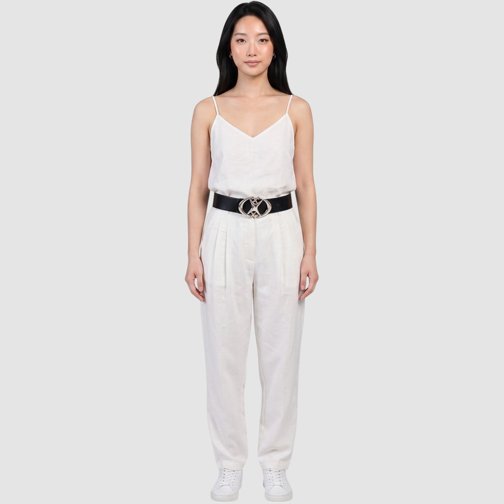 Y2K Avenue black faux leather belt with a silver star-shaped buckle worn by a model in a white linen outfit.