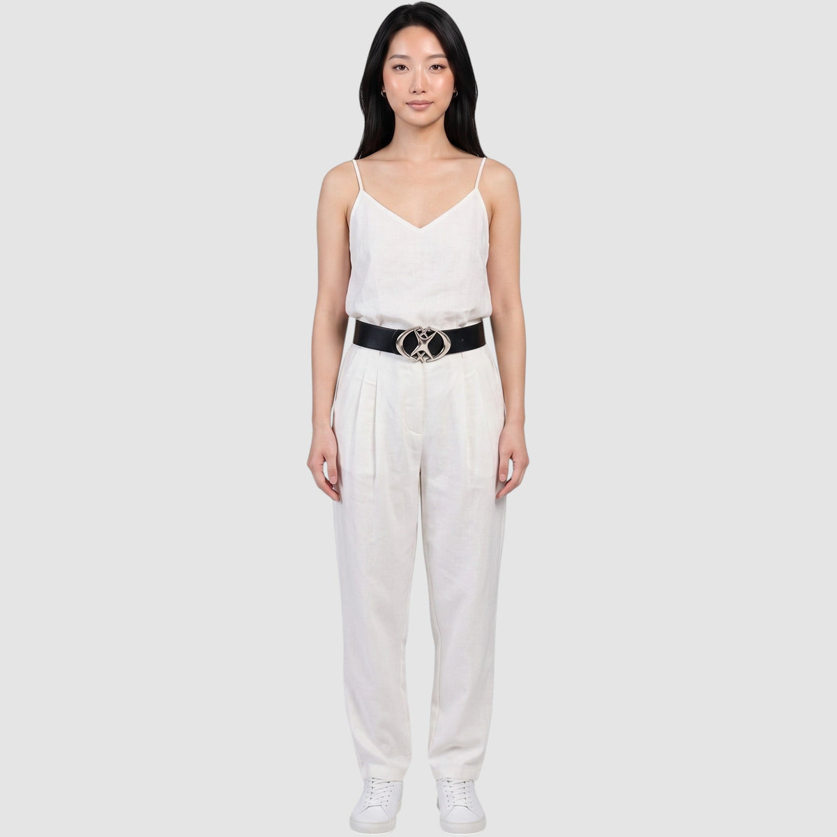 Y2K Avenue black faux leather belt with a silver star-shaped buckle worn by a model in a white linen outfit.