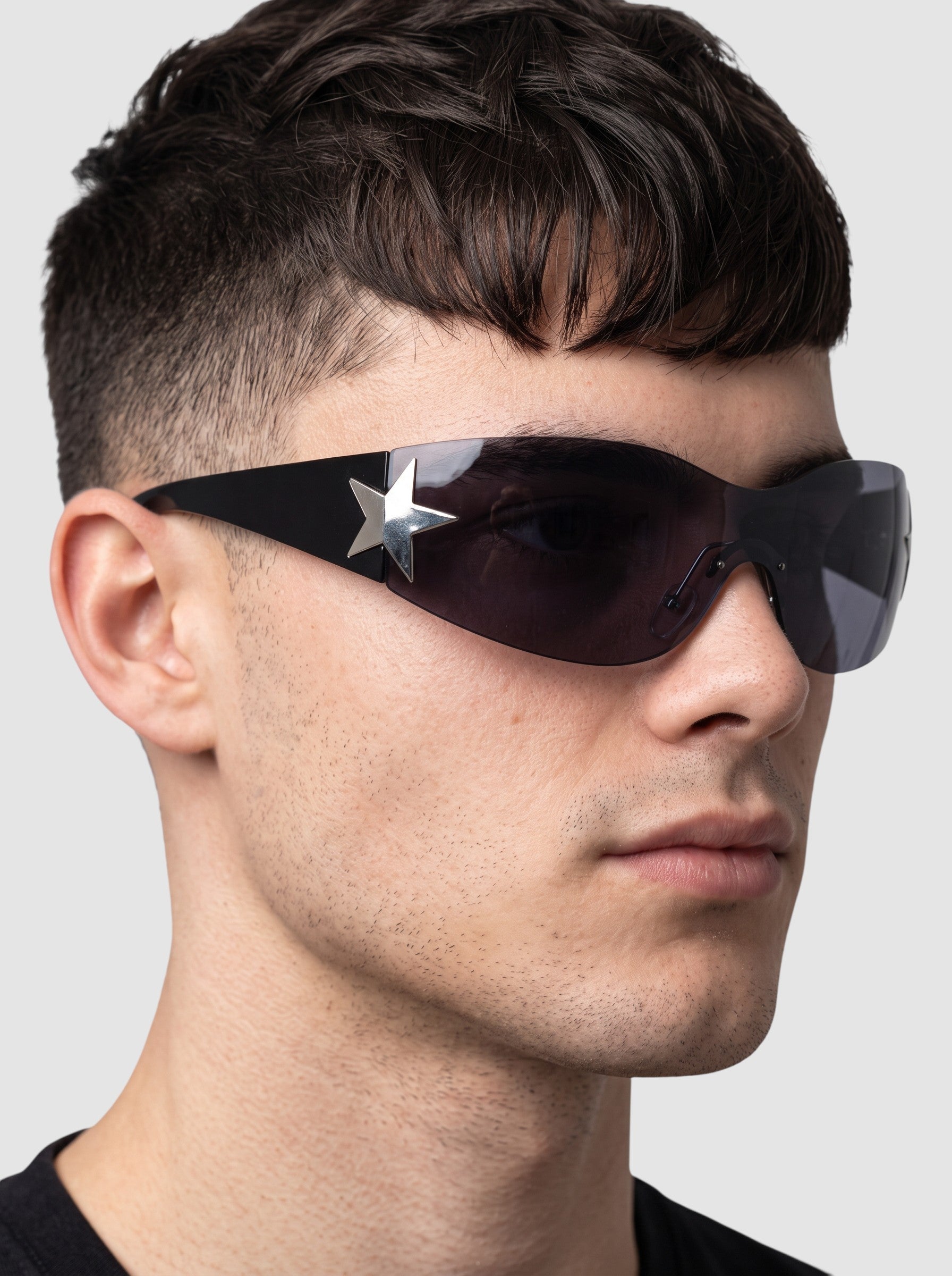 Y2K Avenue black Y2K star mask sunglasses with a single-piece wraparound lens and silver star detail on the temple.