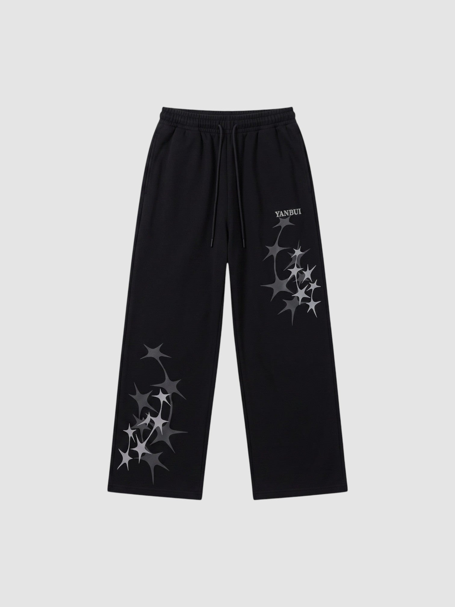 Y2K Avenue black wide leg sweatpants featuring grey four-pointed star prints and an elastic drawstring waistband.