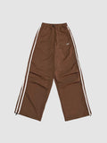Y2K Avenue brown oversized nylon joggers with white side stripes and an elastic high waist with drawstring.