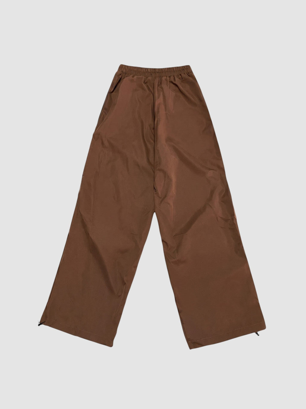 Y2K Avenue brown nylon oversized joggers with high elastic waist and wide leg fit on a plain background