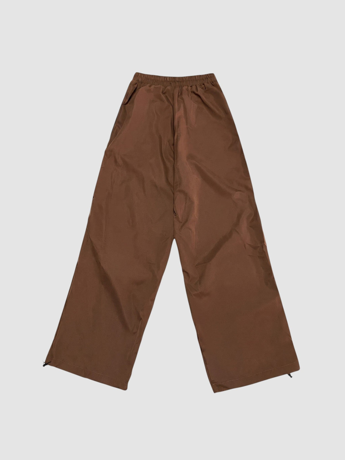 Y2K Avenue brown nylon oversized joggers with high elastic waist and wide leg fit on a plain background