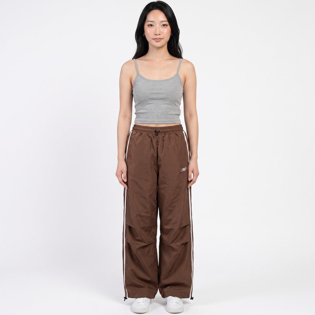 Y2K AVENUE brown oversized nylon joggers with white side stripes and high-waisted fit worn by a model