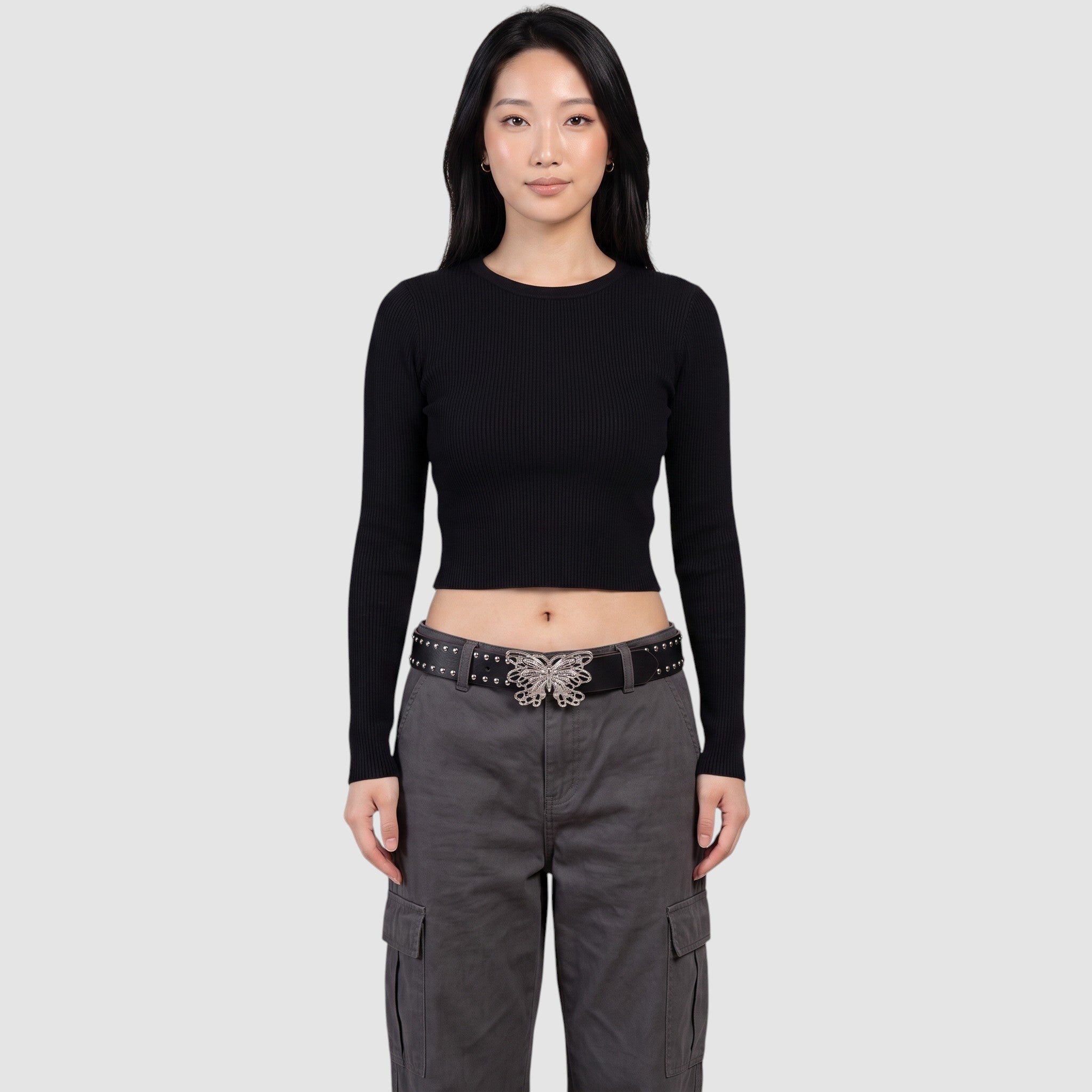 Y2K Avenue black faux leather studded belt with a silver filigree butterfly buckle worn by a model in grey cargo pants