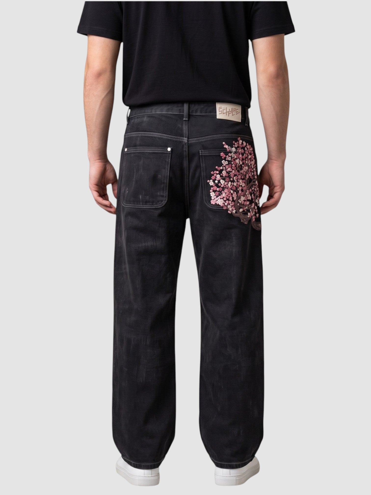 Y2K AVENUE dark denim wide leg jeans with cherry blossom embroidery on the back pocket, worn by a model.