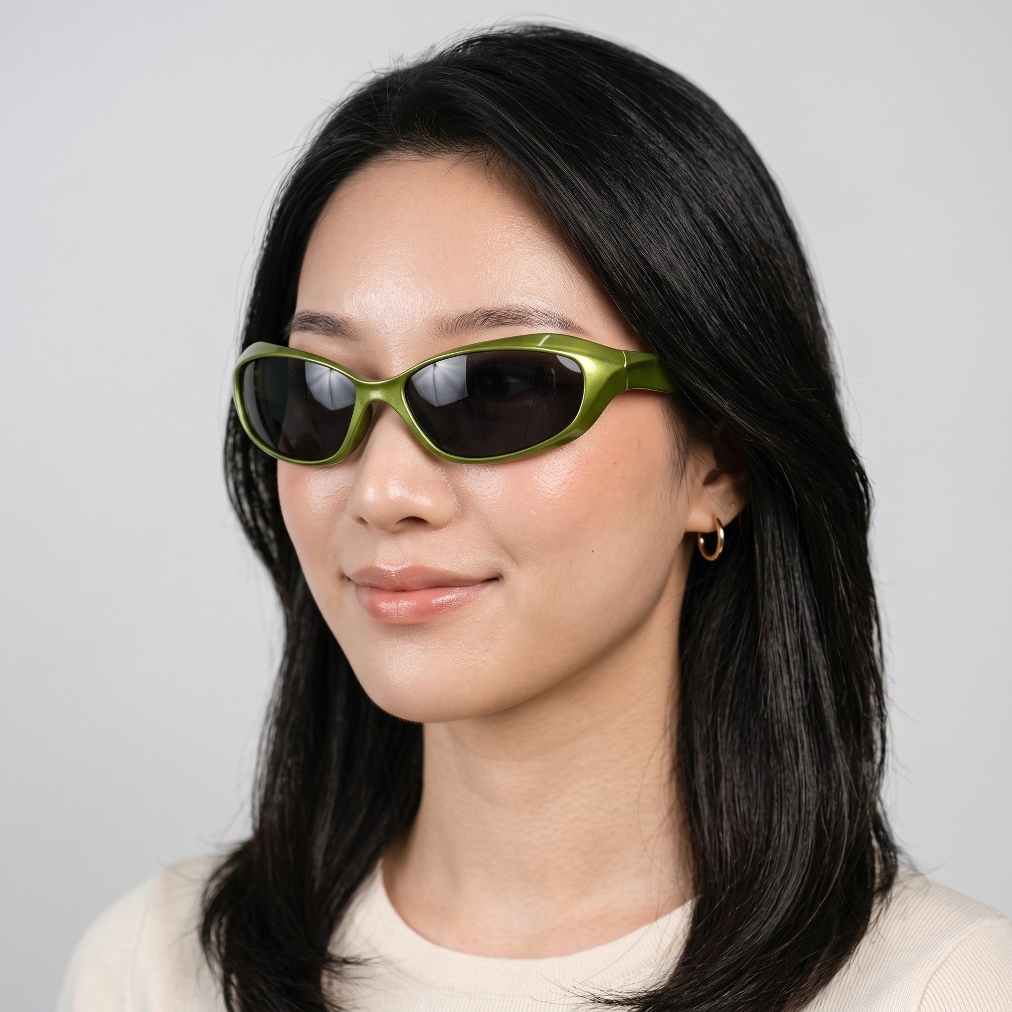 Y2K AVENUE green wraparound futuristic sunglasses with dark lenses worn by a woman against a neutral background