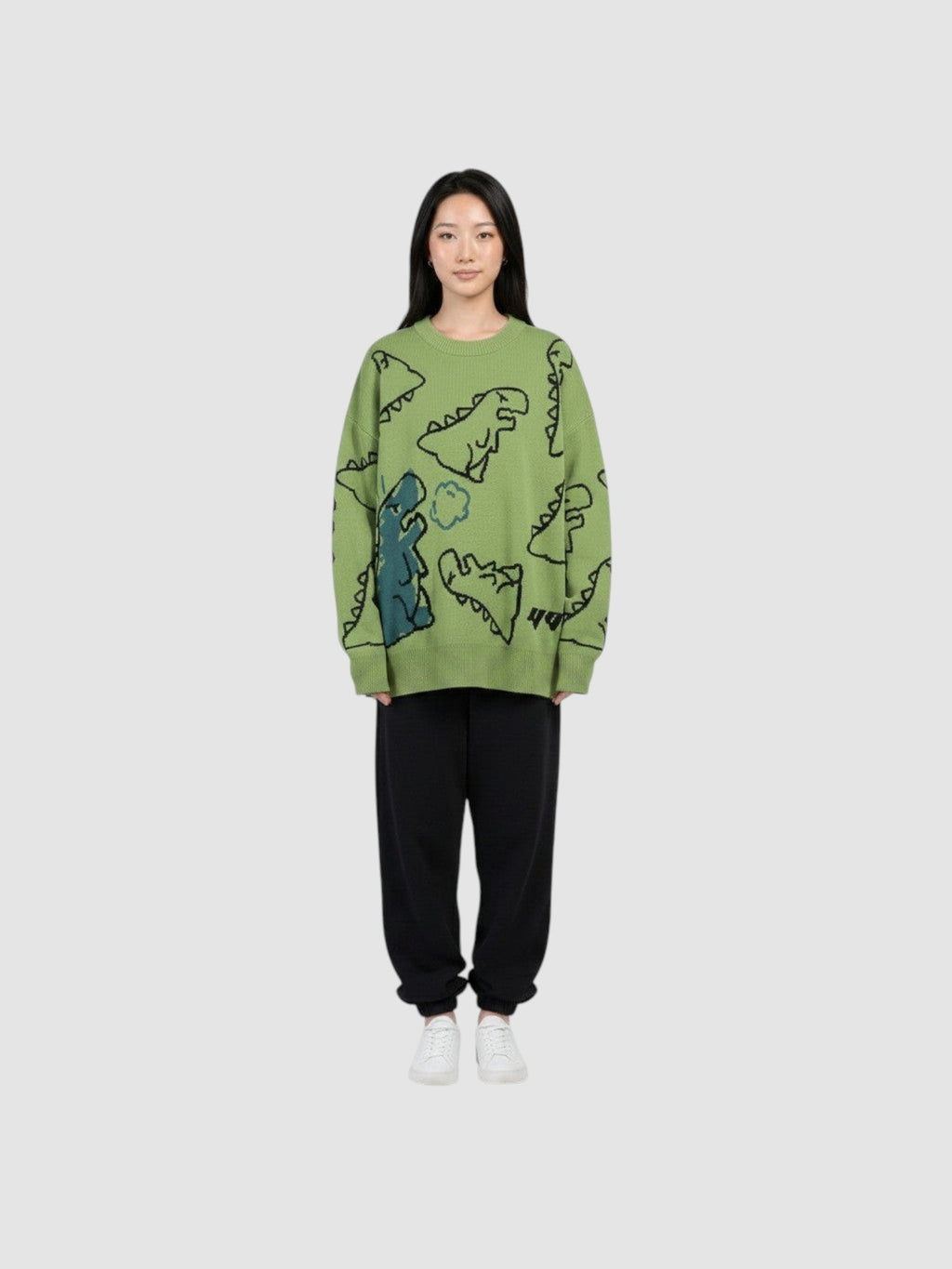 Y2K AVENUE khaki knit sweater featuring a playful cartoon dinosaur pattern, crew neck, and long sleeves on a model.