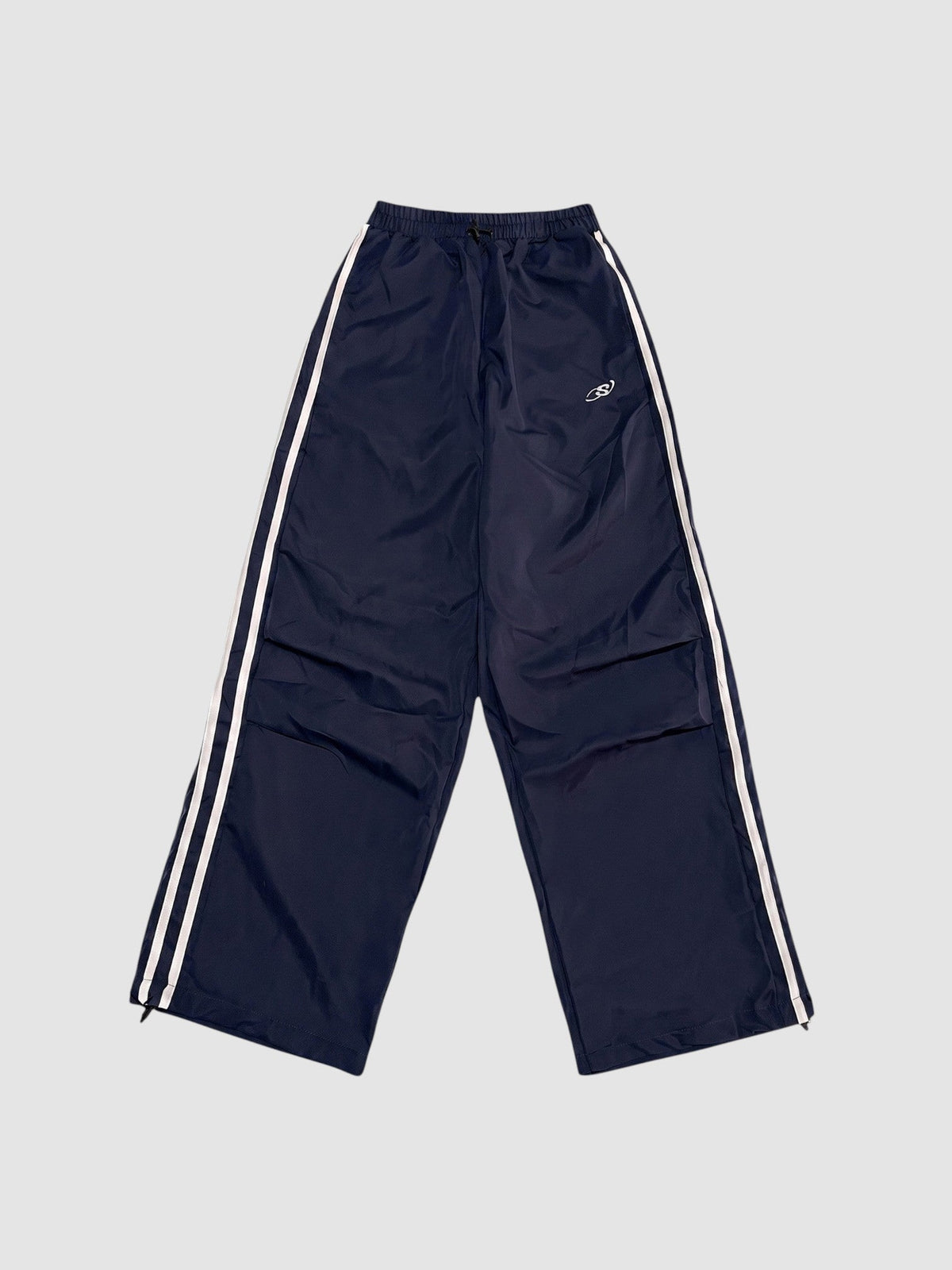 Y2K AVENUE navy blue oversized nylon joggers with white side stripes and an elastic high waist.