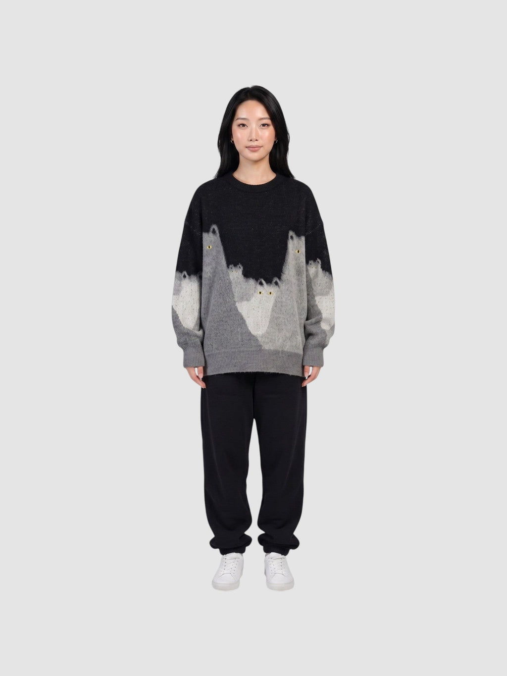 Y2K AVENUE model wearing an oversized black and grey gradient knit sweater featuring cat silhouettes and yellow eyes.