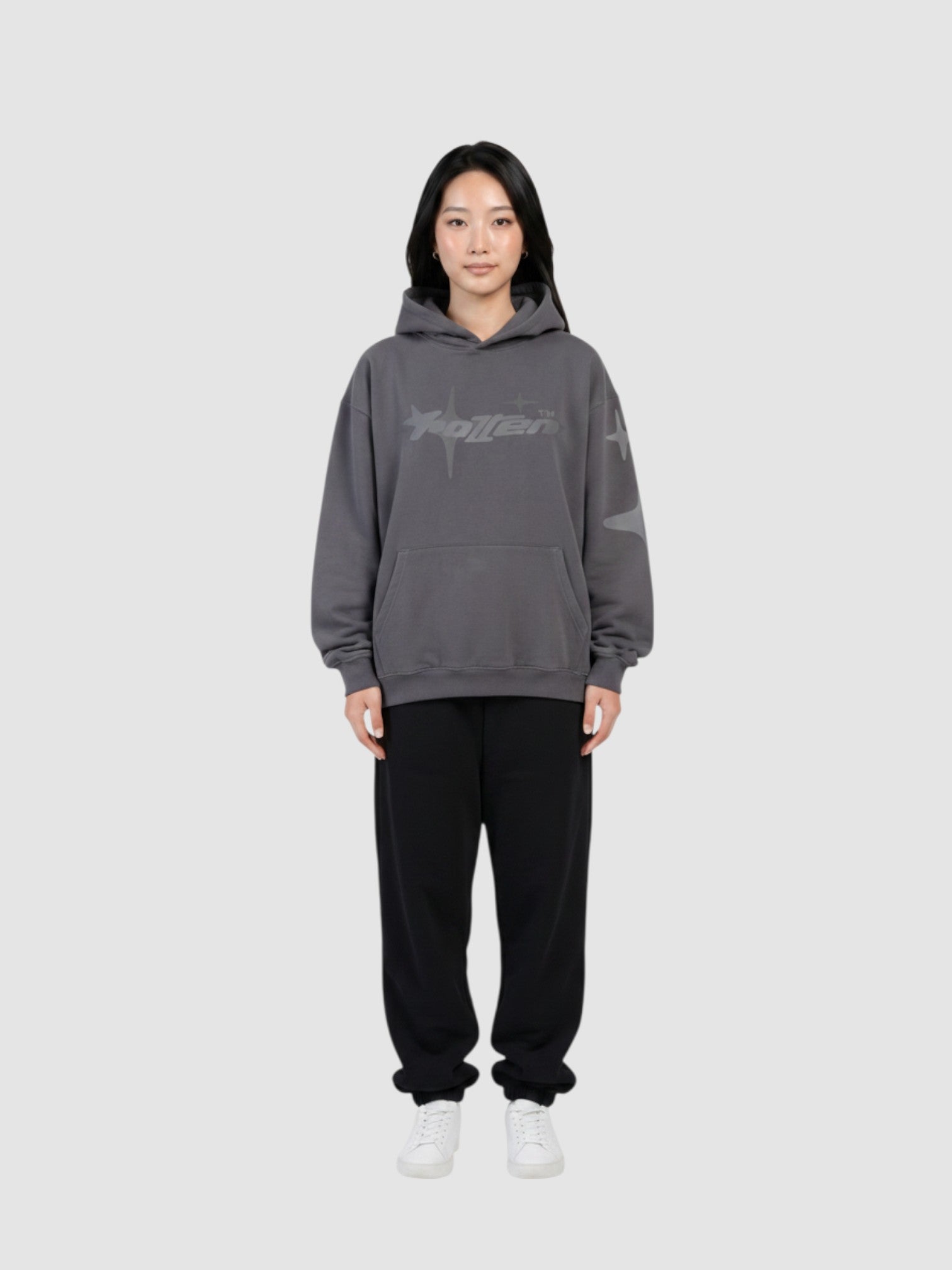 Y2K Avenue oversized grey hoodie with star graphic print, worn by a model with black sweatpants and white sneakers.