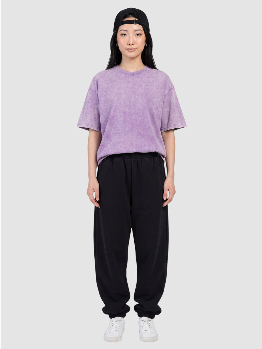 Y2K Avenue purple vintage washed cotton t-shirt with a relaxed fit worn by a woman with a black cap and sweatpants