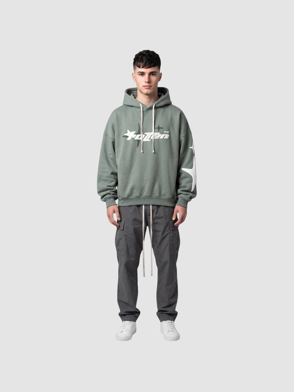Y2K Avenue sage green oversized hoodie with white star graphic and lettering, worn by a male model with cargo pants.